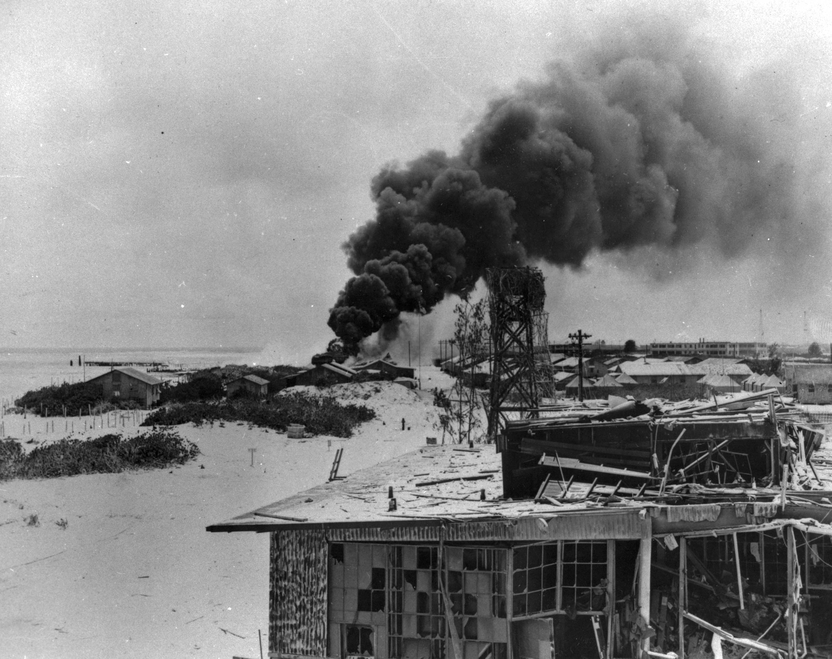 Fires and damaged buildings at Midway from Japanese bombardment during the opening of the Battle of Midway, 4 Jun 1942.