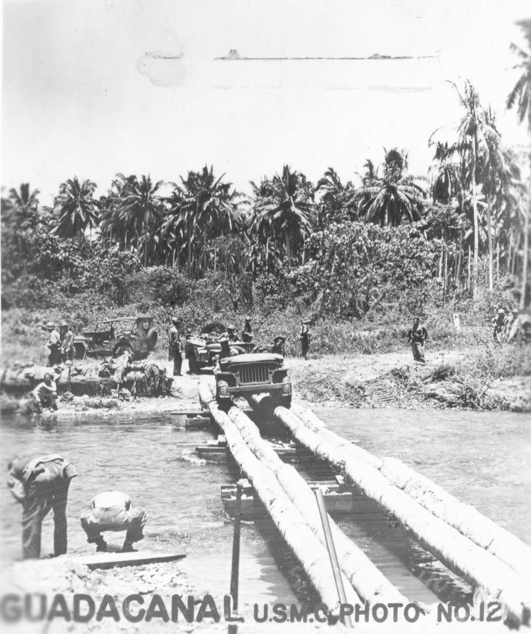 Jeep crossing a coconut tree log bridge over the Bonegi River, Guadalcanal, late 1942