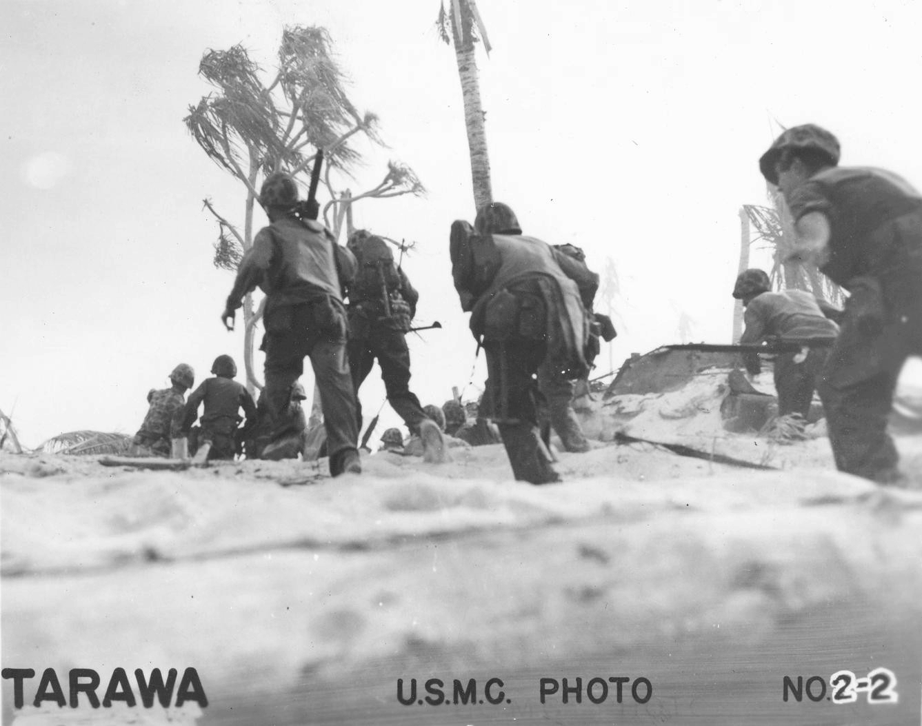 US Marines at Tarawa, Gilbert Islands, 20-23 Nov 1943. Note 2-man .30 cal machine gun team (gunner with the gun on his shoulder and loader two steps ahead with tripod).