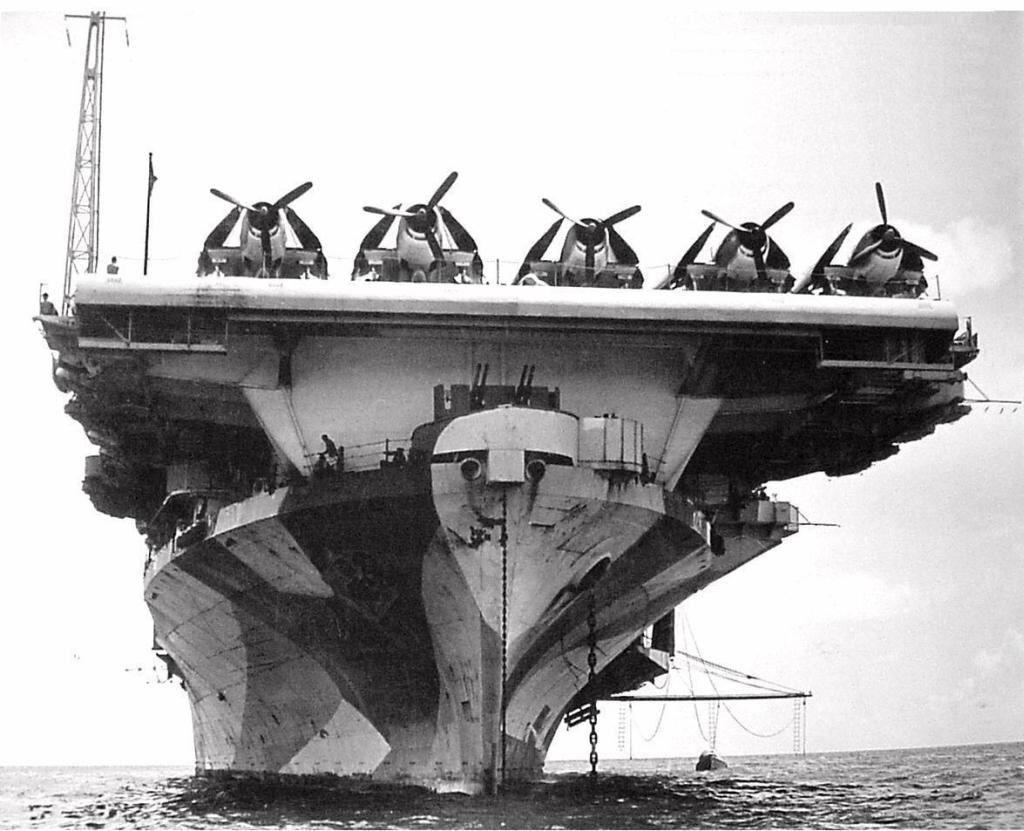 Bow on view of USS Hornet (Essex-class) at anchor in Berth X-14, Majuro Lagoon, Marshall Islands, 29 May 1944. Note F6F Hellcat fighters spotted on the flight deck.