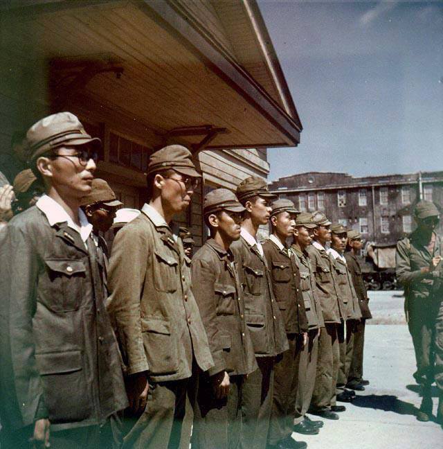 Japanese personnel standing in formation during the surrender of Yokosuka Naval Base, Japan, 30 Aug 1945