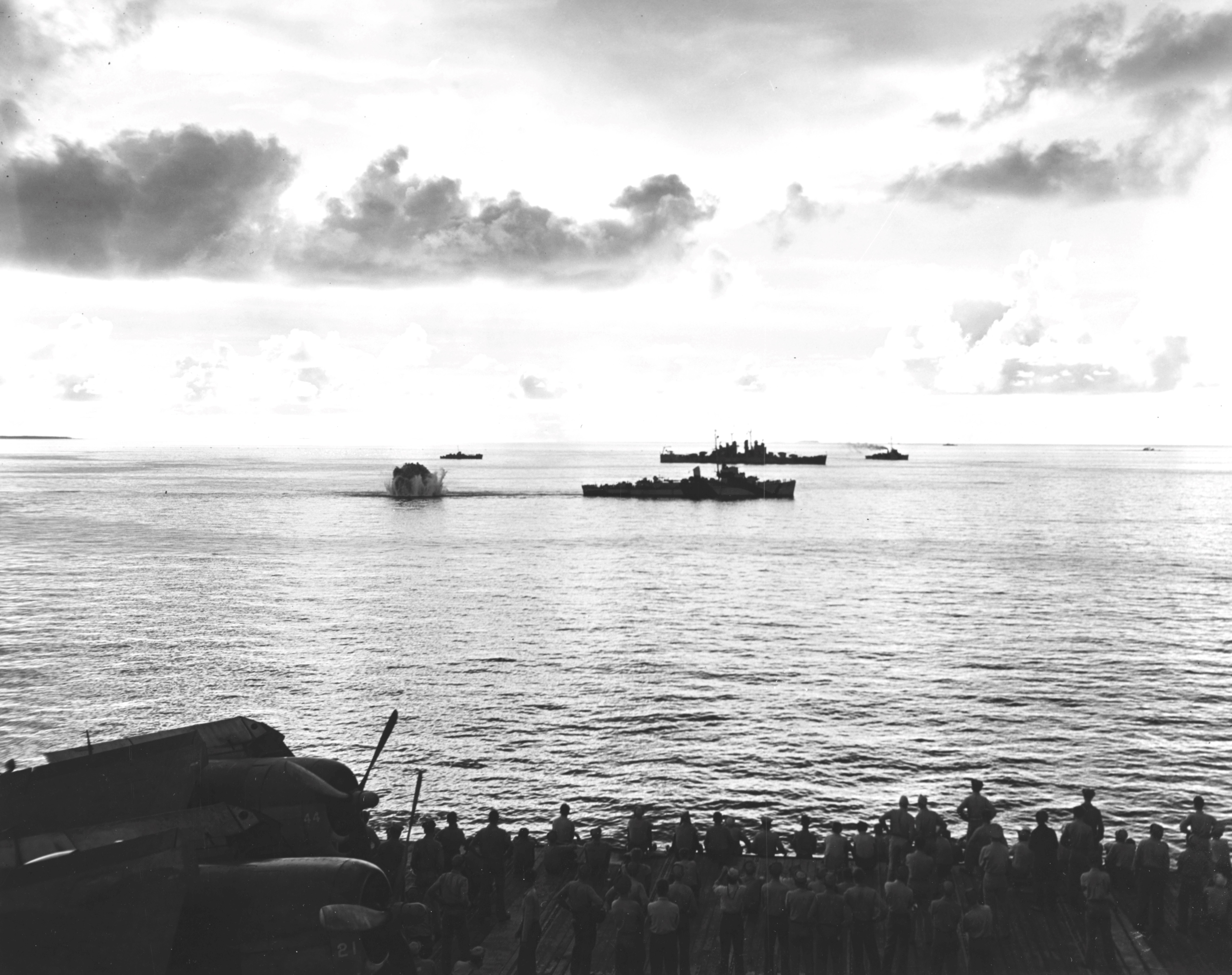 A destroyer escort dropping depth charges on a second Japanese Kaiten in the cruiser anchorage of Ulithi Lagoon on 20 Nov 1944 after the sinking of USS Mississinewa. Seen from USS Bunker Hill. Photo 1 of 3.