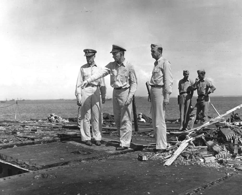 USS Randolph Captain Felix Baker (pointing) showing Admiral Raymond Spruance damage to the flight deck after a P1Y Ginga special attack bomber crashed into the ship at Ulithi, Caroline Islands, 11 Mar 1945.