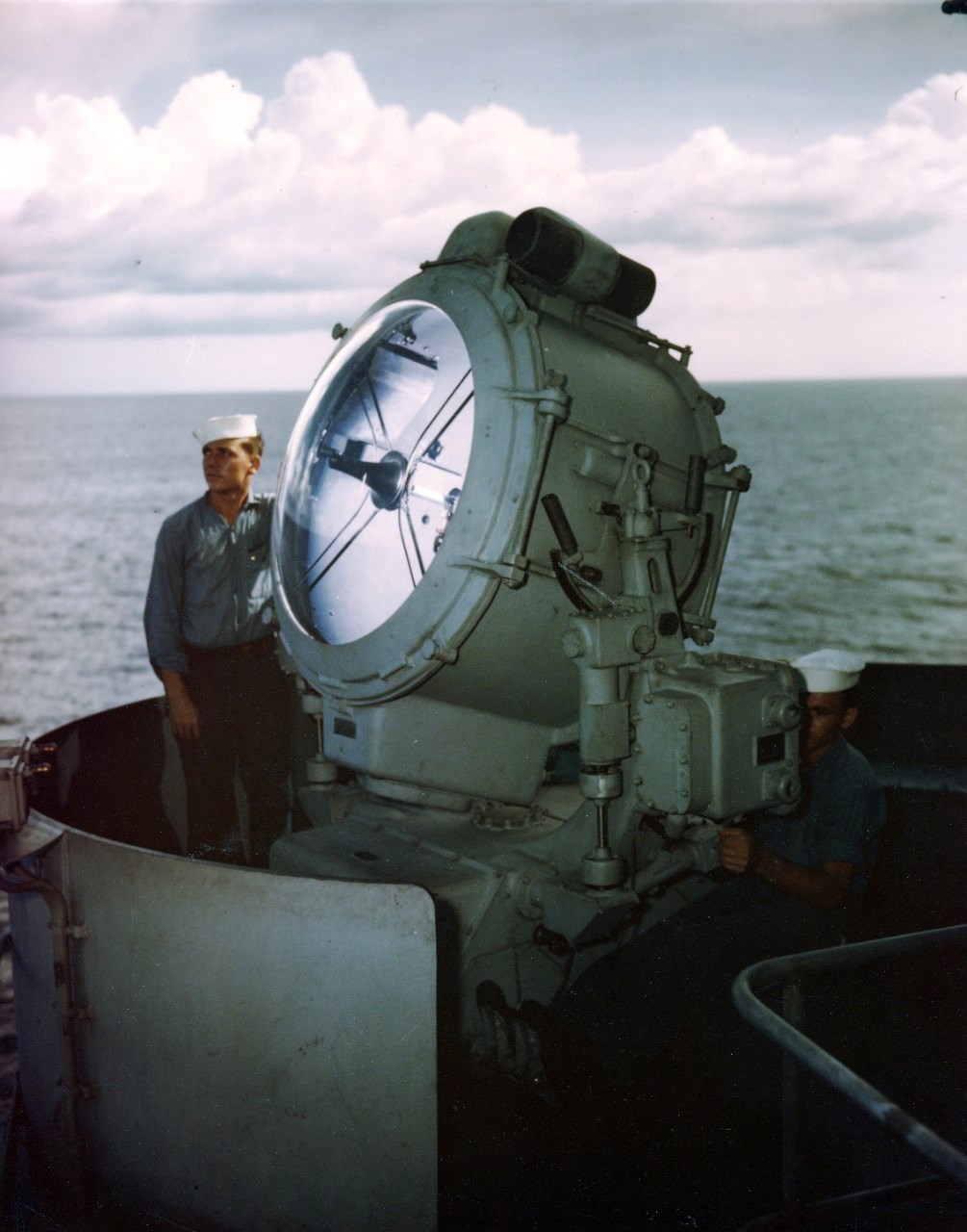 Electrician’s Mate First Class Kenneth McNally and Seaman First Class George Skiratko, kneeling, operating USS Missouri’s 36-inch searchlight during the ship’s shakedown cruise to Trinidad, Aug 1944.