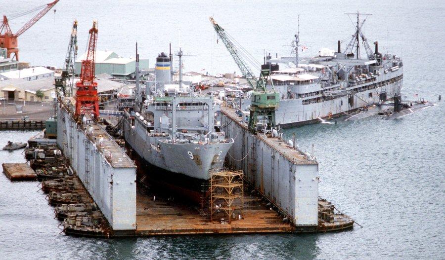 USNS Spica in drydock, Ship Repair Facility Subic Bay, Philippines, 1 Jan 1987; note USS Proteus tending two submarines