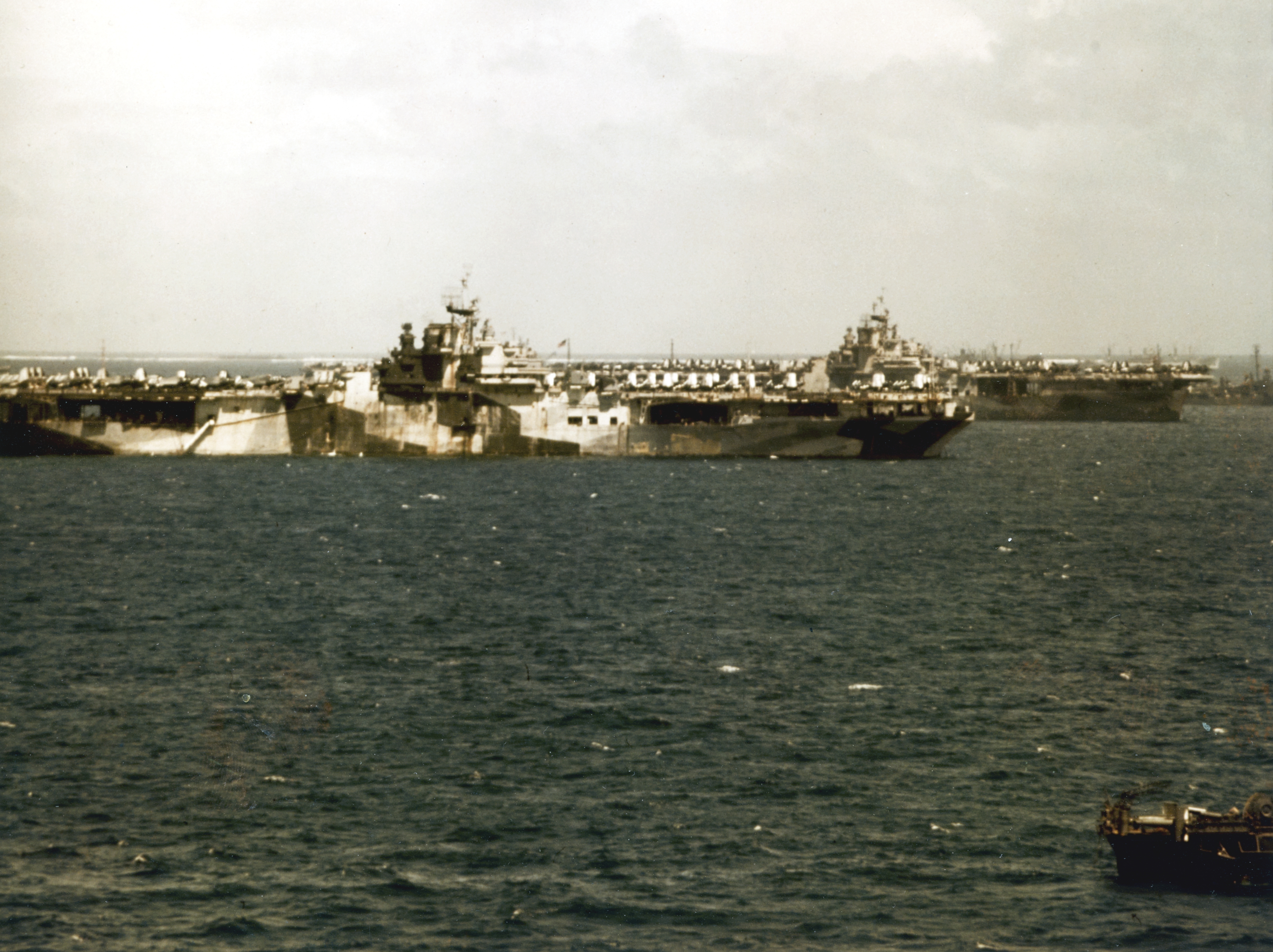 Two (Essex-class) carriers at Ulithi, Caroline Islands, 3 Mar 1945. USS Hancock, in front, is in Berth 22 and USS Wasp is in Berth 29. Both ships show very battle worn paint schemes.