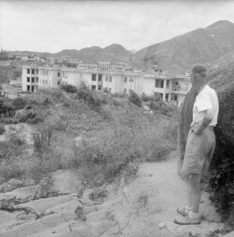 A former internee looking at a building of the Stanley Interment Camp, Hong Kong, 18 Sep 1945