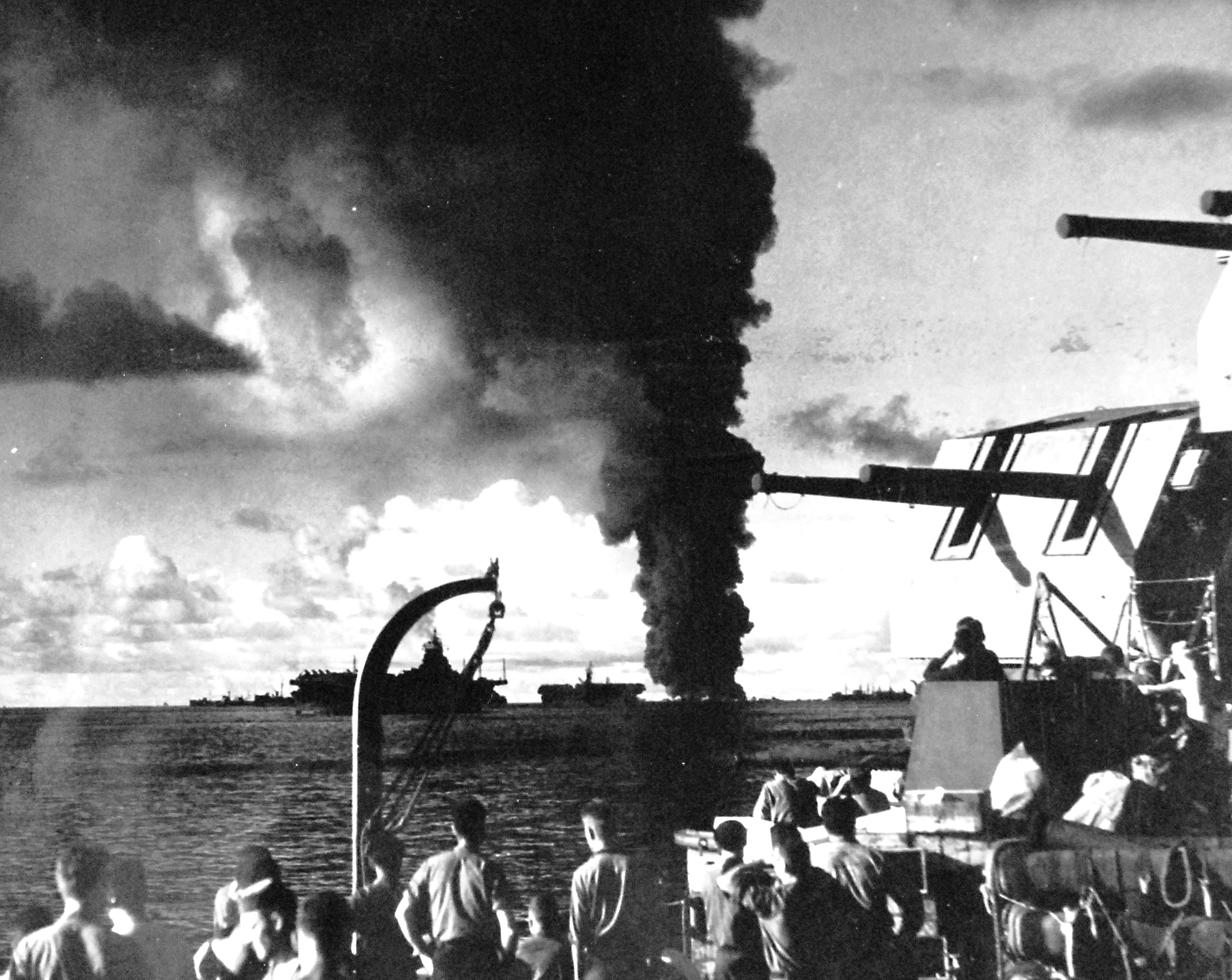Smoke plume from the burning oiler USS Mississinewa in Ulithi Lagoon as seen from the battleship USS South Dakota, 20 Nov 1944. Carriers in the foreground are Bunker Hill and Langley (Independence-class).