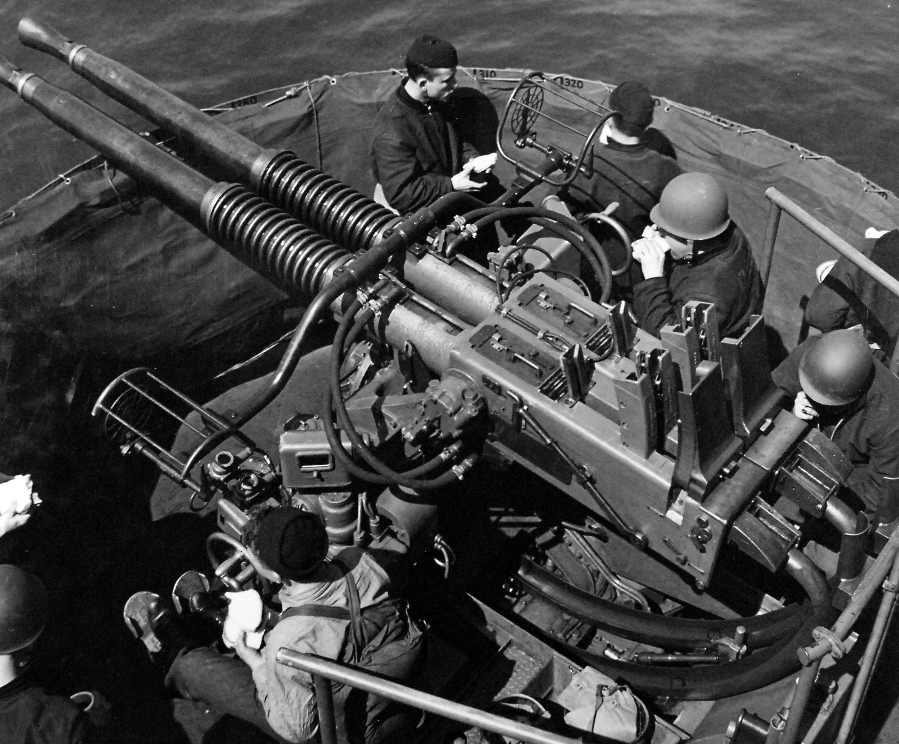 Gun crews on a twin 40mm Bofors anti-aircraft mount take their meals at general quarters aboard the Light Carrier USS Independence in the Caribbean Sea, 30 Apr 1943.