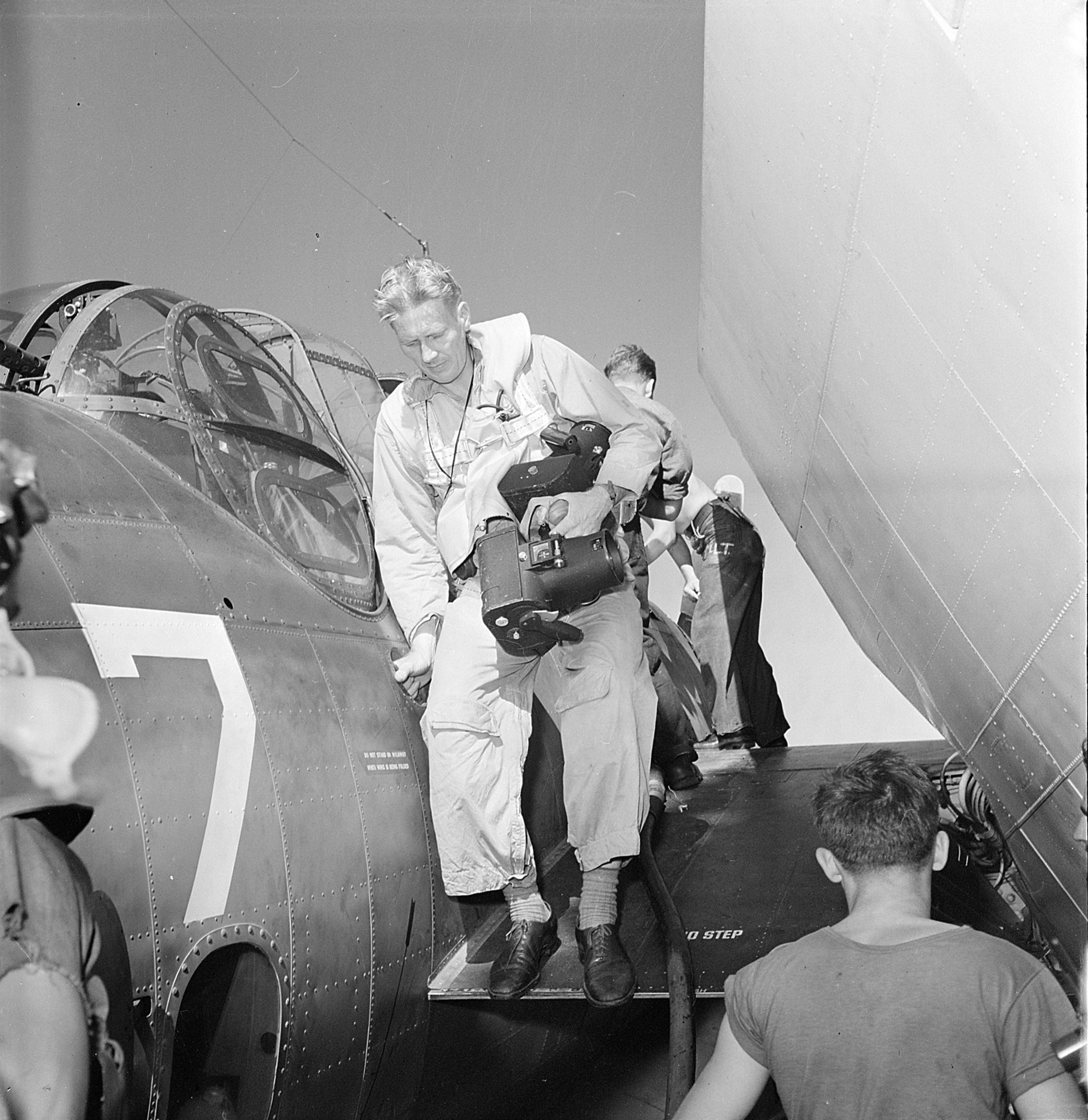 Navy photographer Lt. Charles Kerlee dismounting a TBF Avenger aboard USS Yorktown (Essex-class) after photographing a raid on Wake Island, 6 Oct 1943. Note his two K-20 cameras.