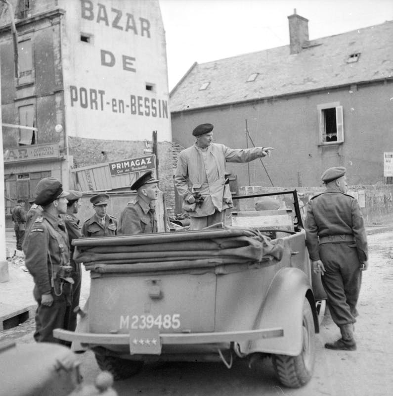 General Bernard Montgomery standing up in his 1943 Humber Super Snipe staff car during a trip to inspect port facilities at Port-en-Bessin, France during the Normandy campaign, 10 Jun 1944.