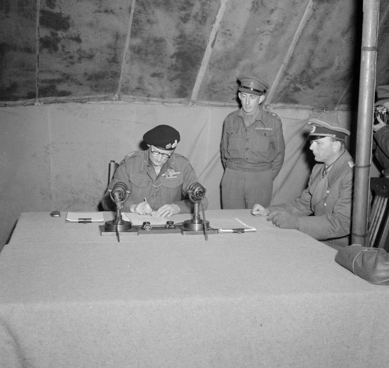 British Field Marshal Bernard Montgomery is the last to sign the documents of surrender as German General Eberhard Kinzel looks on at Montgomery’s headquarters at Lüneburg Heath, Germany, 4 May 1945.