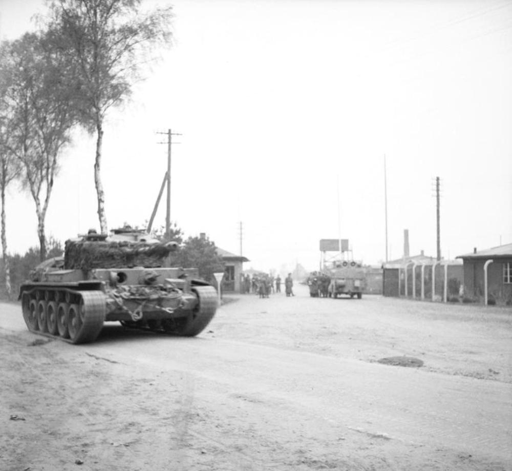 A Comet tank of British 11th Armored Division outside the gate of the Bergen-Belsen Concentration Camp as British troops were first arriving at the camp, 15 Apr 1945.
