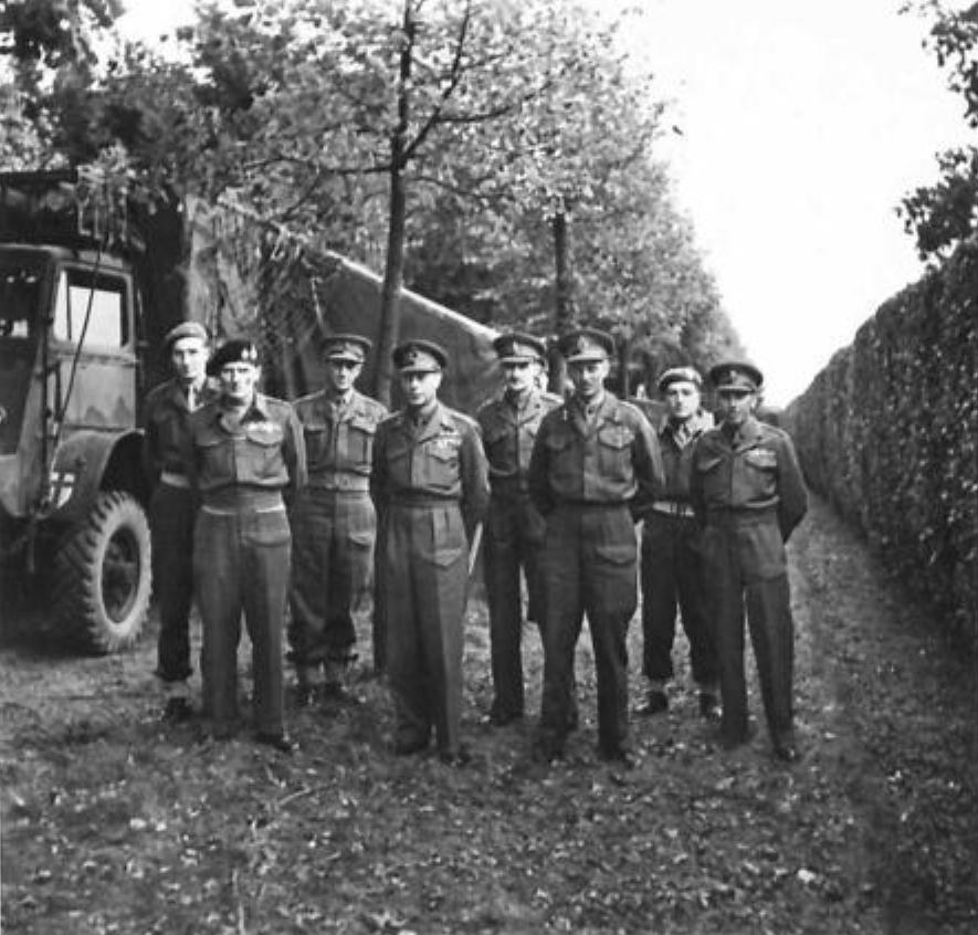 Field Marshal Bernard Montgomery, King George VI of the United Kingdom, and General Miles Dempsey with some of Dempsey’s staff in Holland, 13 Oct 1944.