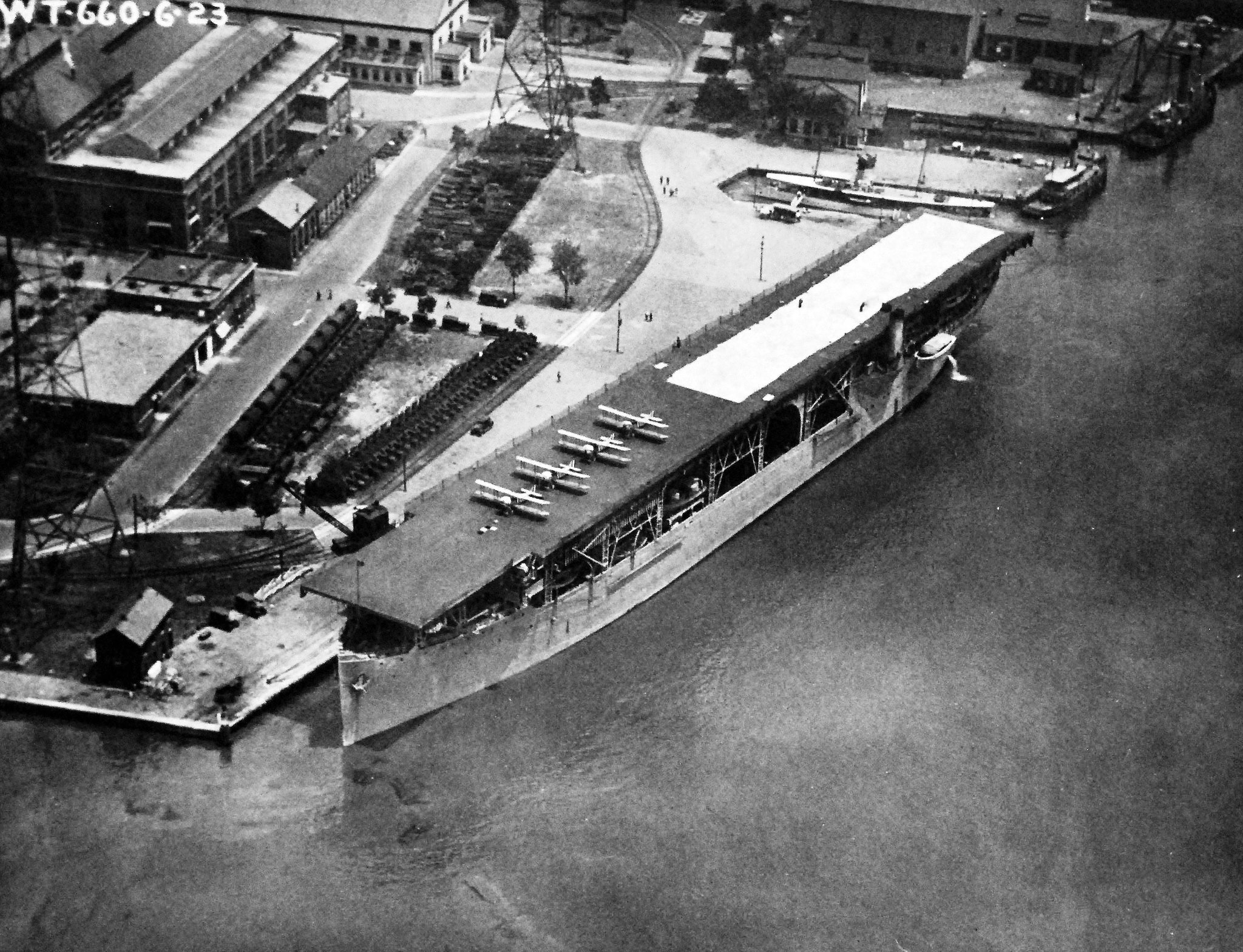 Aircraft carrier USS Langley (Langley-class) alongside the Washington Navy Yard, Washington, DC, United States, 3 Jul 1923. The white building at the photo’s top left is the present day National Museum of the Navy.
