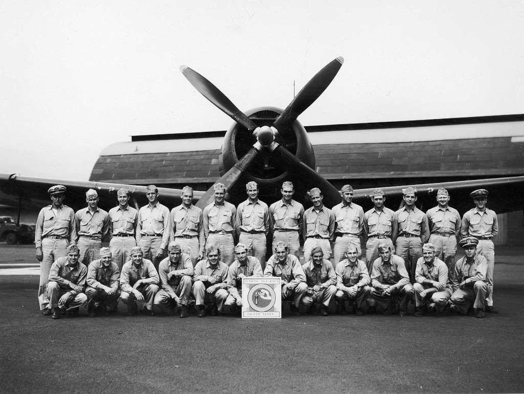 Members of United States Navy Bombing Squadron 87 standing in front of a Curtiss SB2C Helldiver at Kahului Naval Air Station, Maui, Hawaii, Apr 1945.