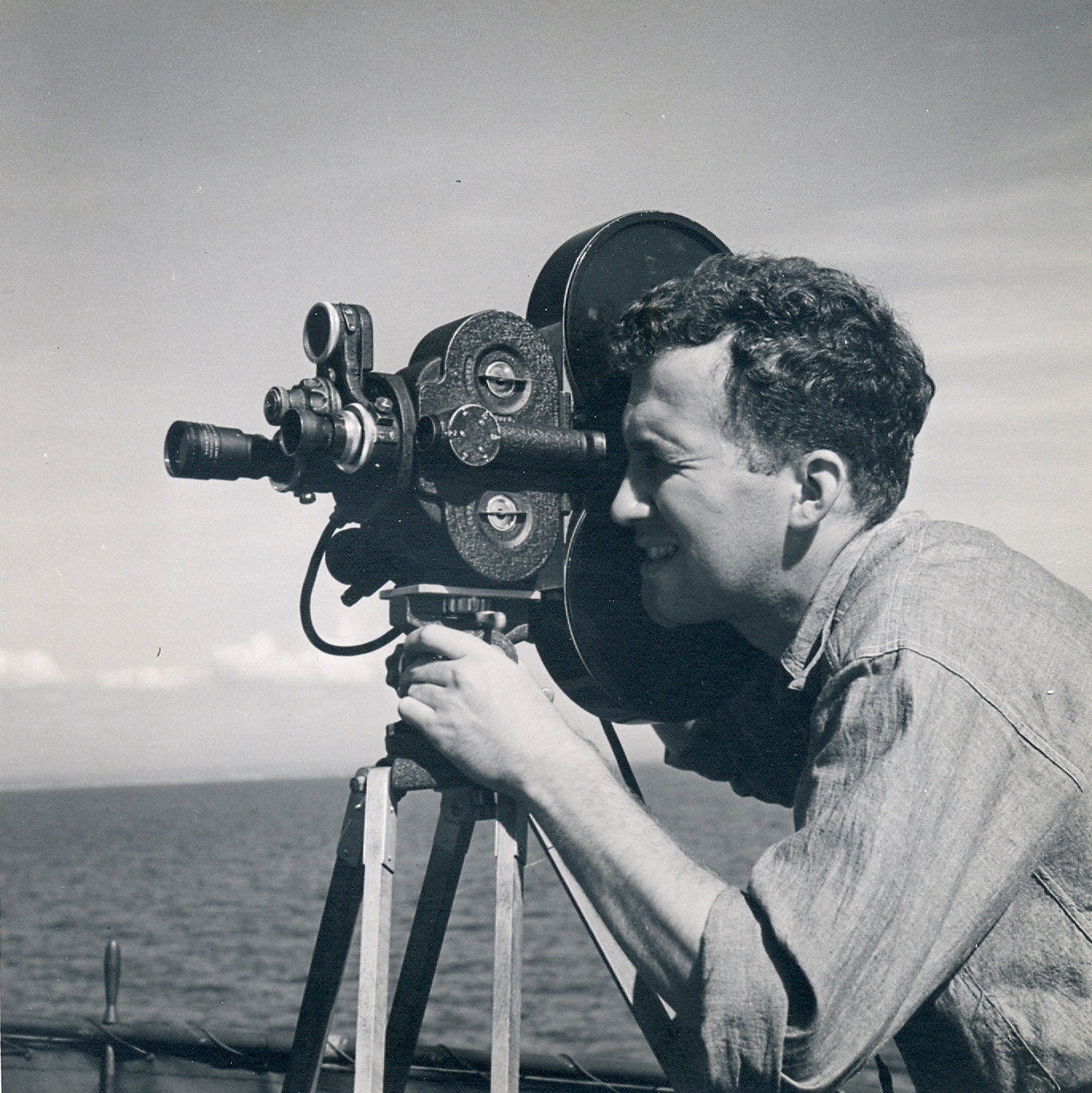 United States Navy photographer operating a movie camera on the flight deck of the USS Saratoga in the South Pacific, circa 1942.