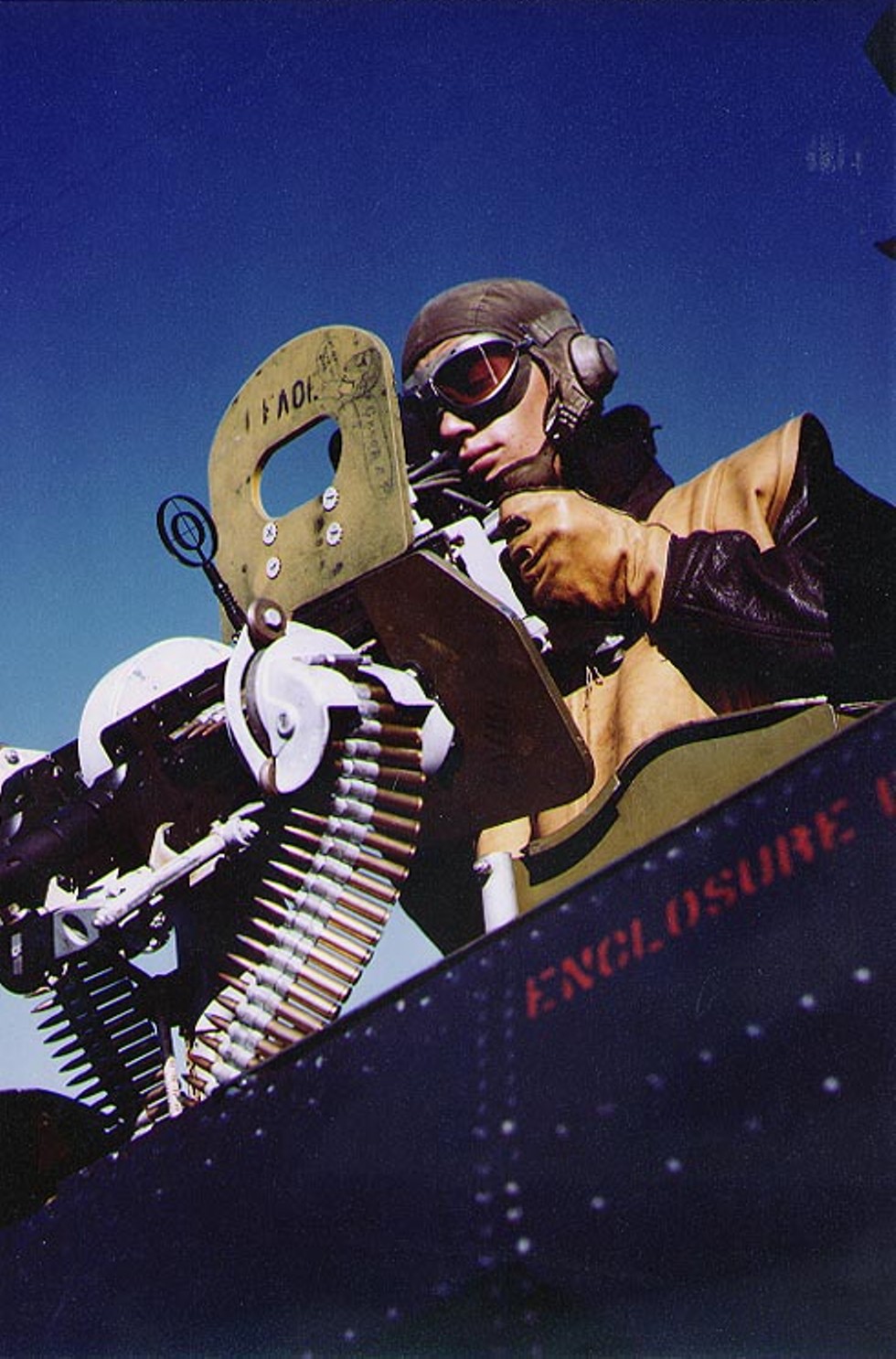 Aviation Ordinanceman poses aiming the twin Browning M1919 .30 caliber machine of an SBD Dauntless scout bomber aboard light carrier USS Independence during her shakedown cruise to Trinidad, 30 Apr 1943.