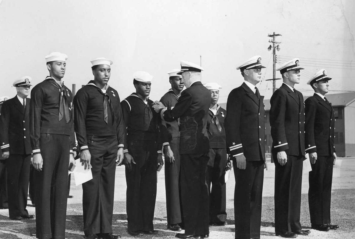 Rear Admiral Carlton H. Wright pinning the Navy and Marine Corps Medal on Seaman 1st-class James A. Camper, Jr. for heroism displayed following the Port Chicago munitions explosion 17 Jul 1944. 26 Oct 1944 photo.
