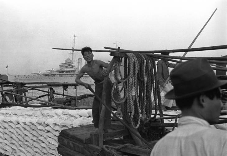 Chinese workers on a pier, Shanghai, China, mid-1937, photo 1 of 5; note HMS Cumberland in background
