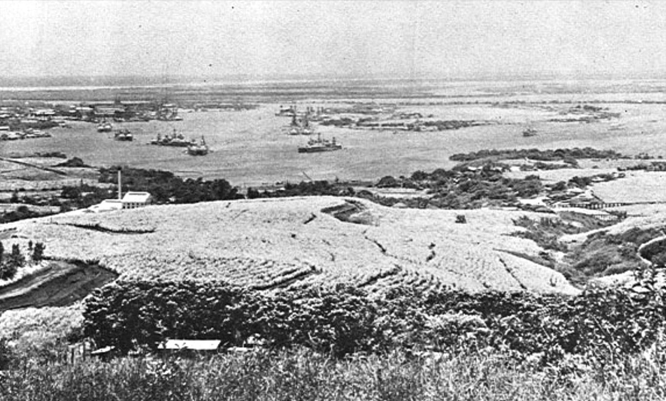 Pearl Harbor, Ford Island, and warships in the harbor as seen from the Aiea Heights in 1932, Oahu, Hawaii. Note the Aiea Sugar Mill on the left.