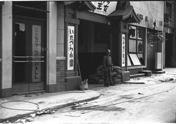 Japanese soldier guarding a war damaged Japanese-owned business, Hongkou (Hongkew) or Yangpu (Yantszepoo) district, Shanghai, China, mid-1937