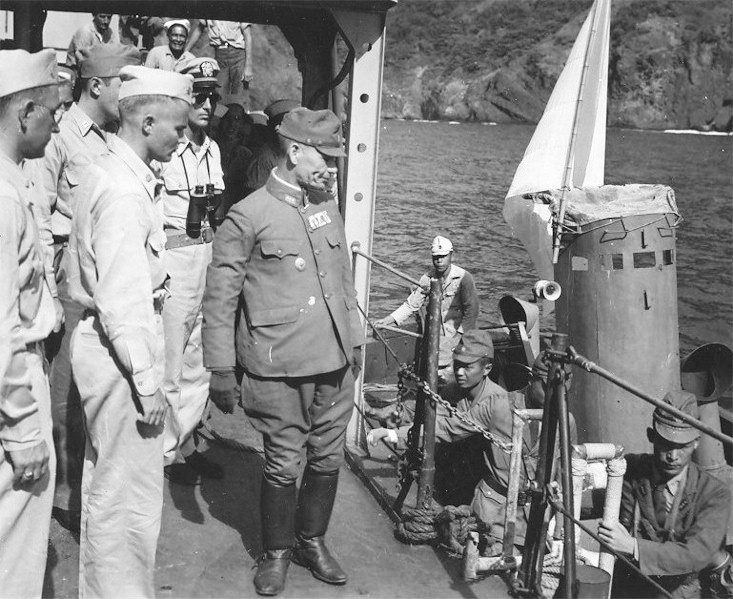 Japanese liaison party boarding destroyer USS Cummings as part of the occupation process at Higashi Harbor, Haha Jima, Bonin Islands, 14 Sep 1945. Note Daihatsu landing craft with white flag.