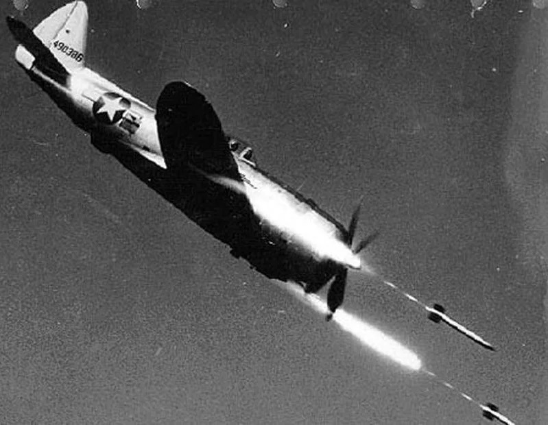 Republic P-47D Thunderbolt 44-90386 firing HVAR air-to-surface rockets at a test range in Independence, Missouri, United States, circa 1945.