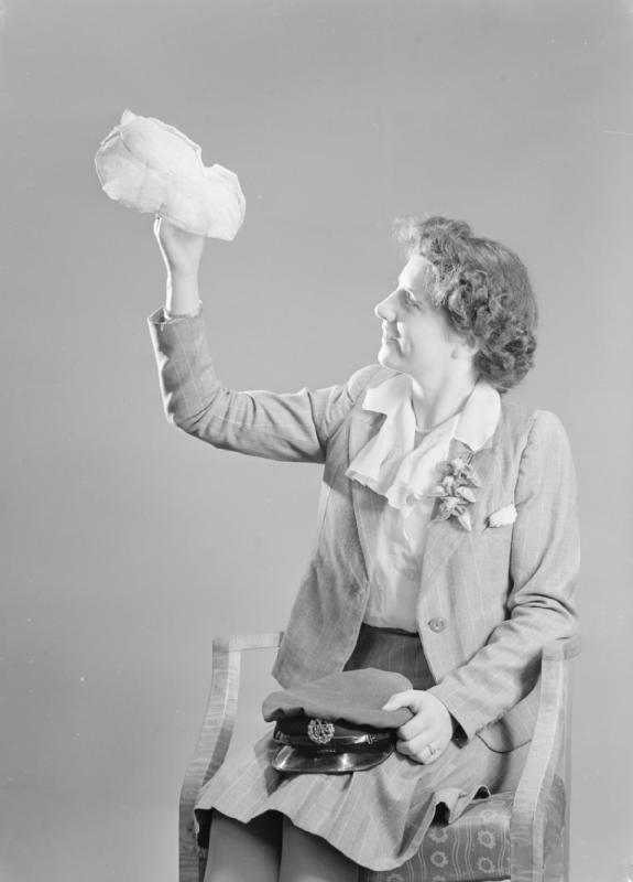Leading Aircraftwoman Vera Blackbee posing with her civilian and military hats, WAAF Demobilisation Centre, RAF Wythall, Worcestershire, England, United Kingdom, 1945