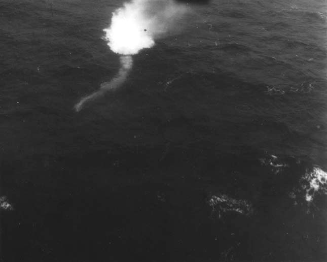 Photo showing a US Navy Mark 24 FIDO acoustic homing torpedo just entering the water. The torpedo can be seen beginning its track toward a submerged submarine. Mid-Atlantic, 13 Oct 1943.