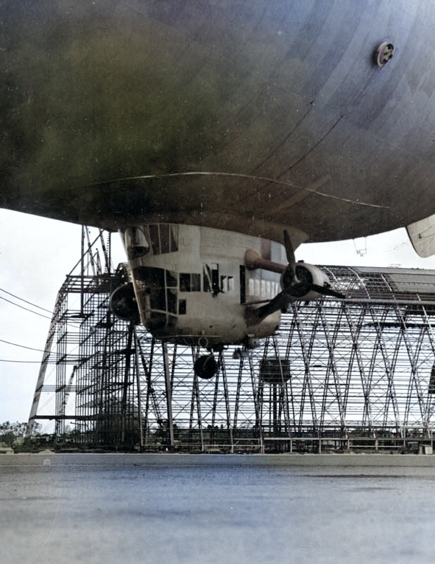 View of the control car of US Navy blimp K-11, Airship Patrol Squadron ZP-11, attempting to land during a storm at NAS South Weymouth, Massachusetts, United States, Sep 27, 1942. Note Hangar One under construction. [Colorized by WW2DB]