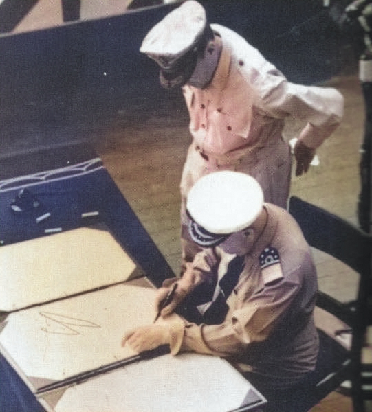 Admiral Conrad E. L. Helfrich signing the Japanese surrender document on behalf of the Netherlands aboard USS Missouri, 2 Sep 1945; note MacArthur next to Helfrich. Photo 2 of 2. [Colorized by WW2DB]