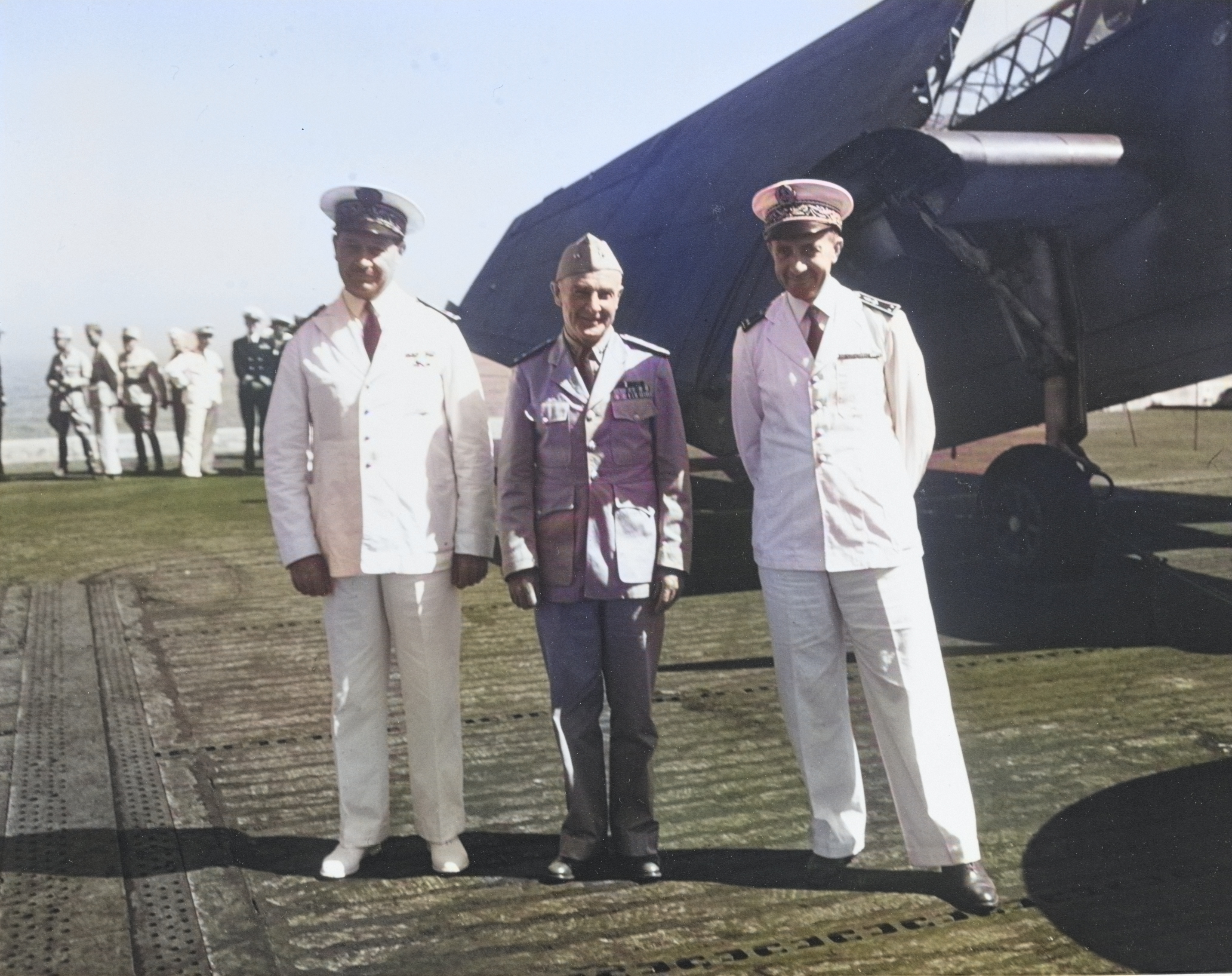 On the flight deck of USS Card in front of a TBF Avenger, US Navy Rear Admiral Frank Lowry (center) is flanked by two Rear Admirals of the French Navy, C.A. Ronarc’h (left) and Jacques Missoffe, Casablanca, 4 Jun 1943. [Colorized by WW2DB]