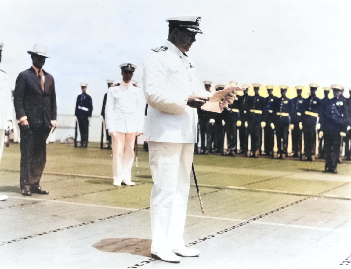 Captain Arthur L. Bristol reading his orders to take command of USS Ranger upon her commissioning at Norfolk, Virginia, 4 May 1934. Note the Marine detachment at the edge of the flight deck. [Colorized by WW2DB]