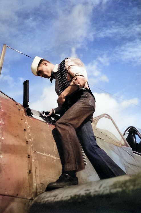 US Navy ordnanceman loading .50 caliber ammunition for a F2A Buffalo fighter, Naval Air Station Miami, Florida, United States, 9 Apr 1943 [Colorized by WW2DB]