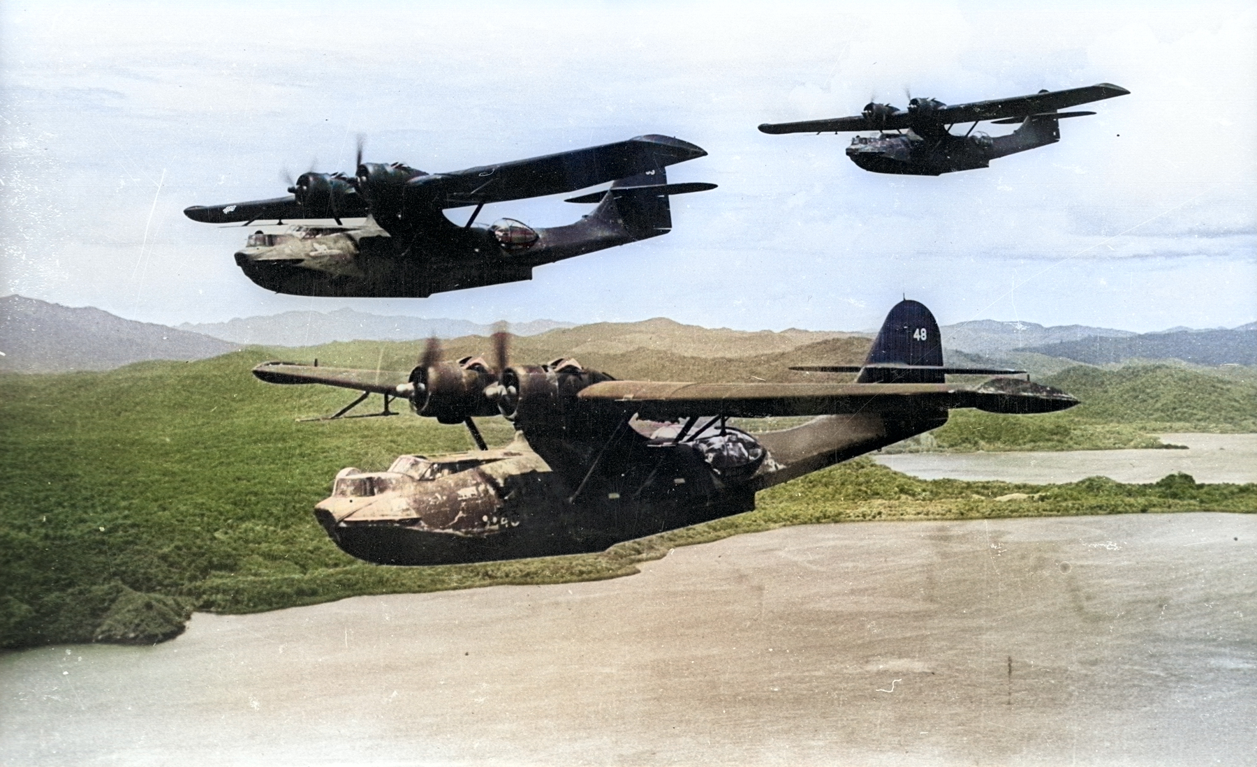 Three US Navy PBY-5A Catalina aircraft of VP-52 in flight in the southwest Pacific, Dec 1943 [Colorized by WW2DB]