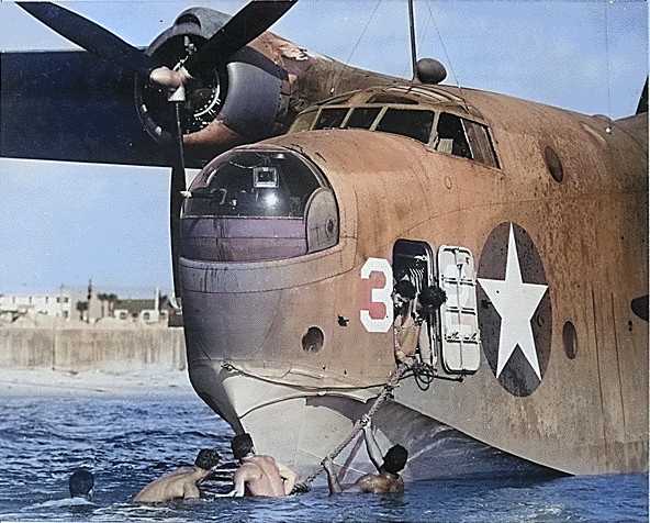 An US Navy beaching crew clinging to the tow line of a PBM Mariner aircraft, Naval Air Station Banana River, Florida, United States, circa Mar 1943 [Colorized by WW2DB]