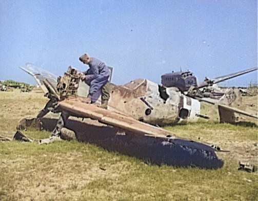 A French soldier looking over the wreckage of a German Bf 109 fighter at the El Aouiana airfield, Tunisia, circa May-Jun 1943 [Colorized by WW2DB]