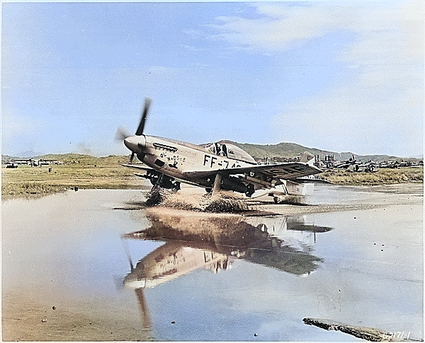 F-51 Mustang fighter taxiing through a puddle, Korea, circa Sep 1951 [Colorized by WW2DB]