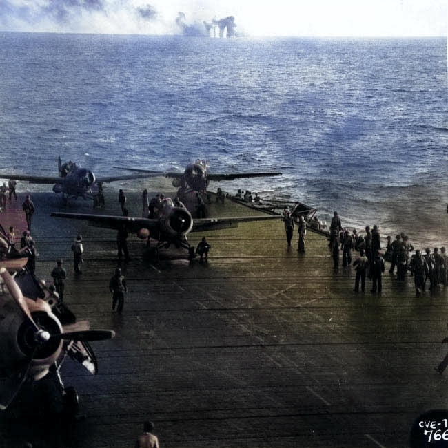 USS Kitkun Bay prepared to launch FM-2 Wildcat fighters during Battle off Samar, 25 Oct 1944; note shell splashes in background [Colorized by WW2DB]