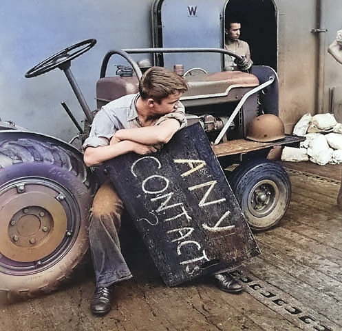 An American aircraft carrier deck crewman resting between aircraft landings, off Tarawa, Gilbert Islands, circa Nov 1943 [Colorized by WW2DB]