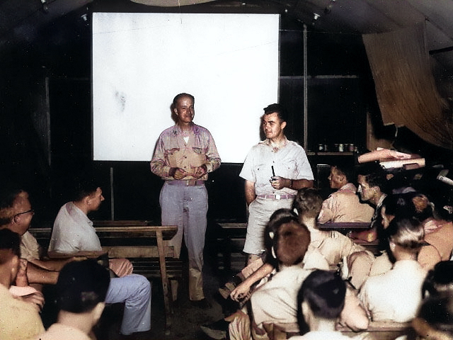 Captain William Sterling Parsons and Colonel Paul Tibbets, Jr. briefed the crew of B-29 Superfortress 'Enola Gay' before the Hiroshima attack, 5 Aug 1945 [Colorized by WW2DB]