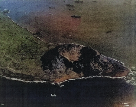 View of the southwestern face of Mount Suribachi, Iwo Jima, Japan, 7 Mar 1945; photo taken from an aircraft of USS Anzio [Colorized by WW2DB]