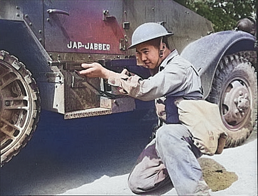 An ethnically Chinese soldier of the US Army posing with a Thompson sub-machinegun next to a halftrac armored car, Fort Knox, Kentucky, United States, Jun 1942 [Colorized by WW2DB]