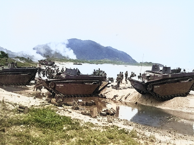 Amphibious tractors delivering US Marines and supplies on the beach of Ibeya, an island in the Ryukyu Islands northwest of Okinawa, 3 Jun 1945 [Colorized by WW2DB]