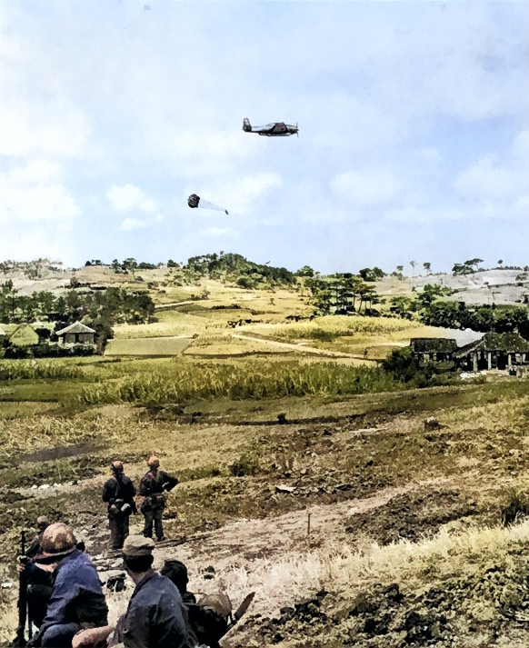 US Navy TBM-R or TBM-S Avenger aircraft dropping supplies in Korea, circa 1950-1953 [Colorized by WW2DB]