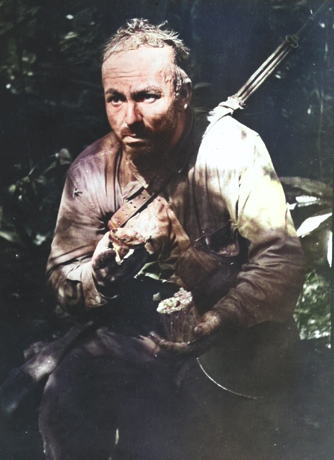 US Army Private Lloyd Culuck of A Company, 1st Battalion, US 172nd Infantry Regiment eating a can of Ration B, using the lid as spoon while wearing 12-day-old dirty clothes, New Georgia, Solomon Islands, Jul 1943 [Colorized by WW2DB]