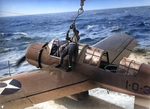 OS2U Kingfisher aircraft recovered alongside battleship Arizona, near US Territory of Hawaii, 6 Sep 1941, photo 2 of 2; observer dismounting onto wing to attach hoisting cable