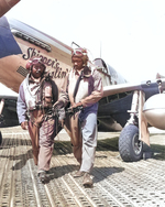 Capt Andrew D Turner, 100th Fighter Squadron CO, and Lt. Clarence P. (Lucky) Lester on the Marsden Matting of Ramitelli Airstrip, Italy. Behind them is Maj Turner’s P-51C “Skipper’s Darlin’ III.” 1 Aug 1944. Photo 2 of 2.