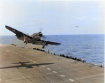 SB2C Helldiver getting a wave-off from USS Bunker Hill, 1943. Note Helldiver in the distance with wheels up but flaps down, apparently preparing for a water landing.